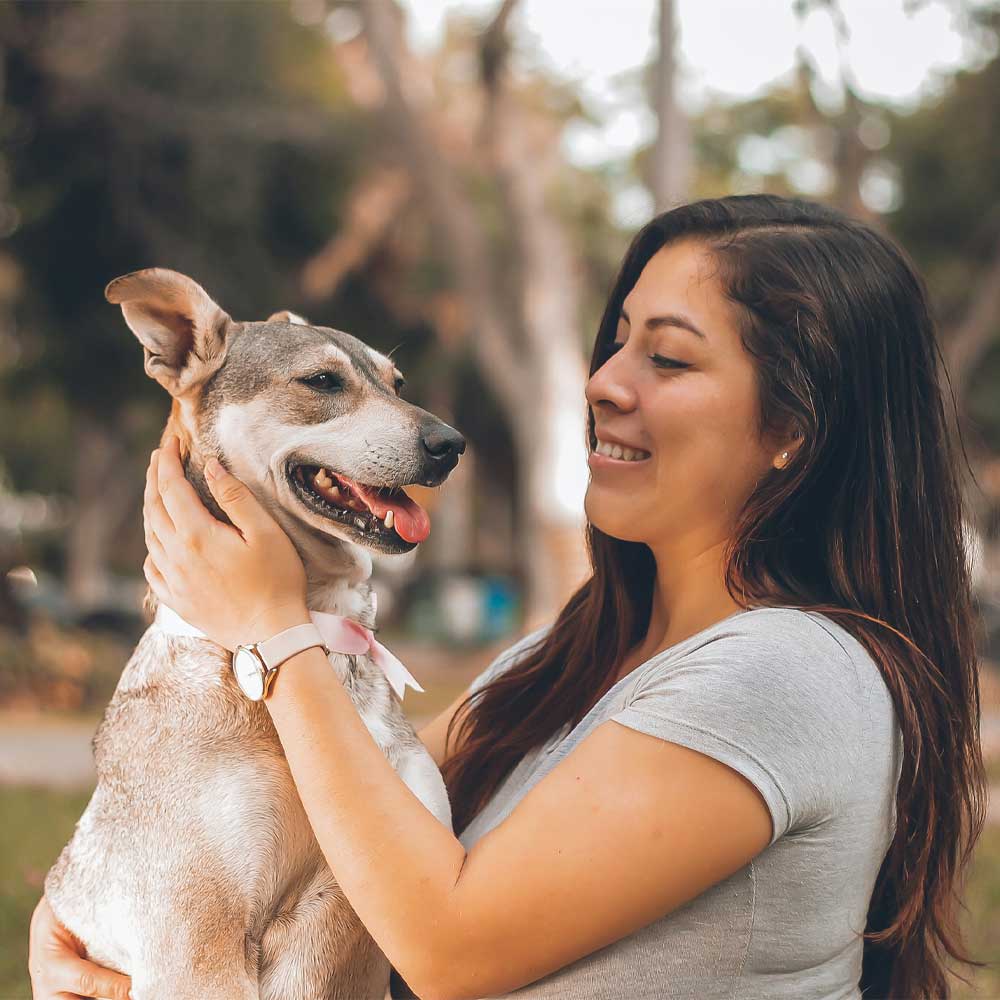 Woman smiling holding a dog